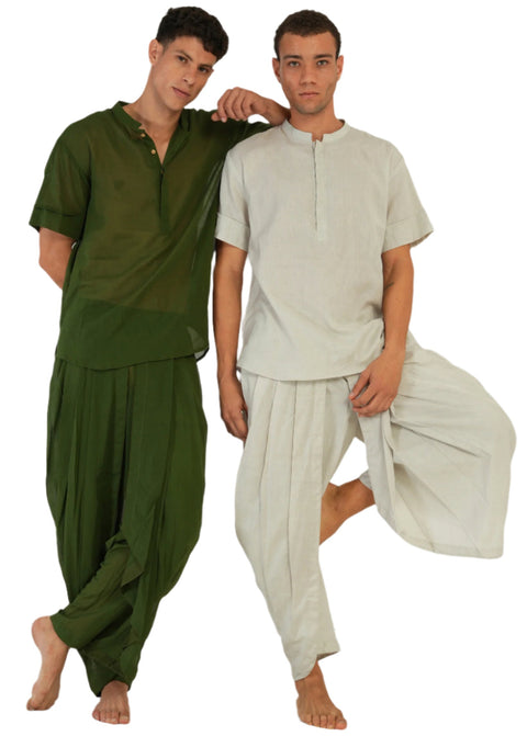 Two men in Mehndi green and Tulsi natural YogaFlow sets — barefoot, relaxed, one balancing in tree pose, the other gently leaning in.