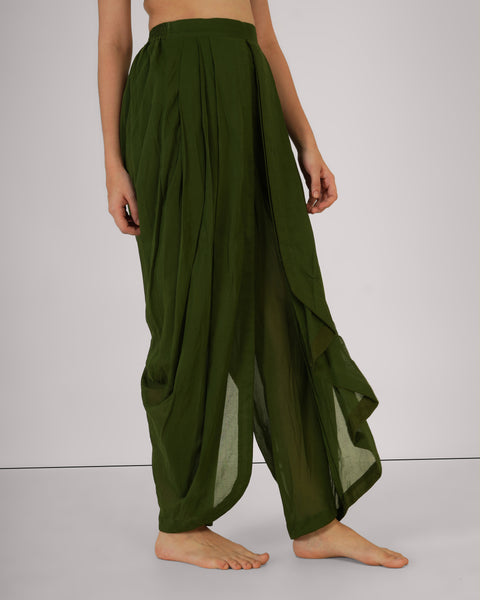 Female standing relaxed, side view, wearing Mehndi green cotton yoga pants, natural breathable fabric, studio white background.