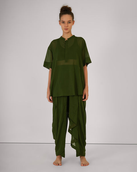 Female standing straight, front view, wearing Mehndi green 100% cotton yoga set, breathable natural fabric, white studio background.