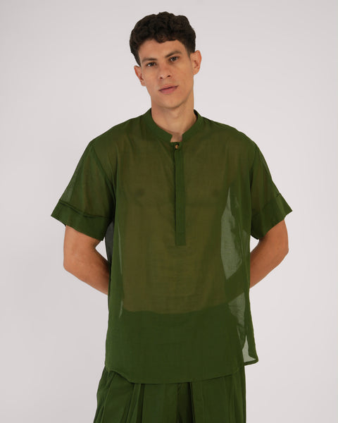 Front close-up of male wearing Mehndi green cotton yoga top, natural breathable fabric, relaxed pose, white studio background.