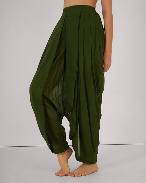 Female in relaxed side stance, wearing Mehndi green cotton yoga pants, highlighting drape and breathable natural fabric, white studio background.