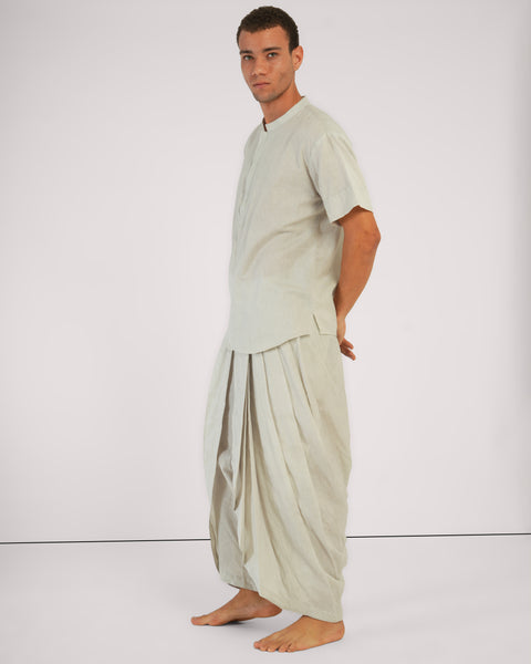 Side view of male model standing relaxed wearing Vibhuti Grey linen cotton yoga set, breathable natural fabric, white studio background.