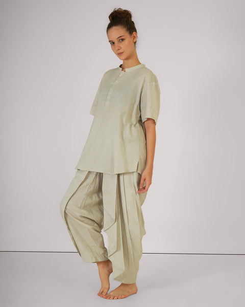 Female standing casually in Vibhuti Grey linen cotton yoga set, side-view highlighting natural breathable fabric, white studio background.