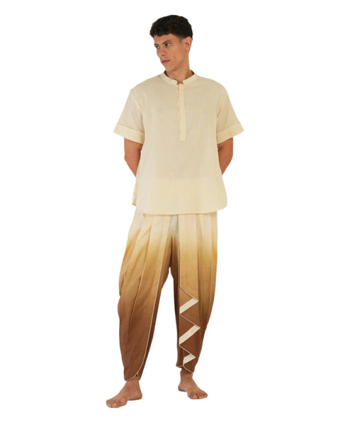 Man standing in Cinnamon Ombre YogaFlow set — pleated dhoti-style pants in linen cotton paired with a soft natural kurta top.