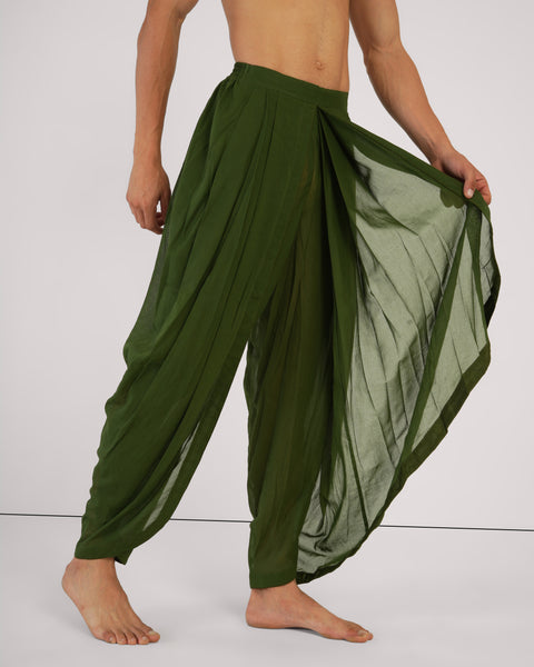 Side view of male model stretching out Mehndi green 100% cotton yoga pants, demonstrating natural fabric drape, breathable, white studio background.