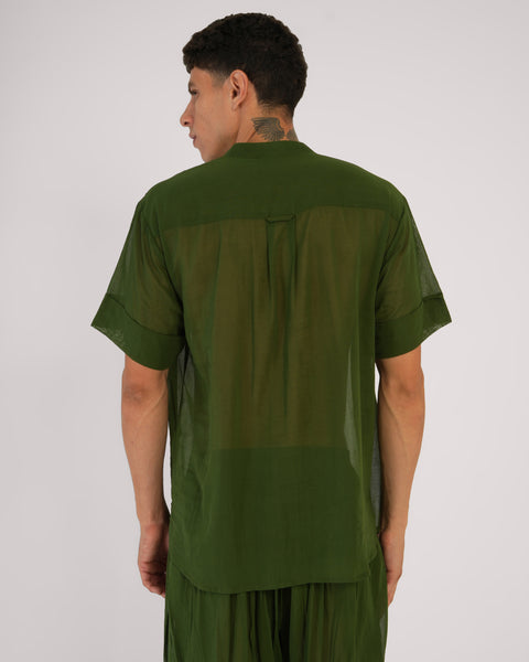 Male standing facing away, close-up of Mehndi green cotton yoga top, highlighting breathable natural fabric, white studio background.