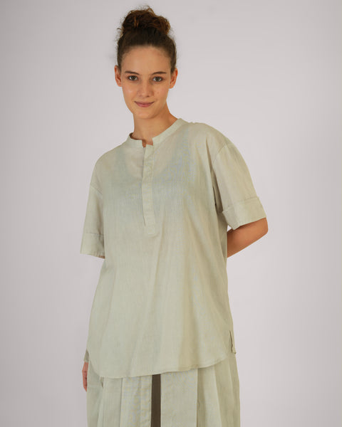 Front close-up of smiling female model wearing Vibhuti Grey linen cotton yoga top, natural breathable fabric, white studio background.